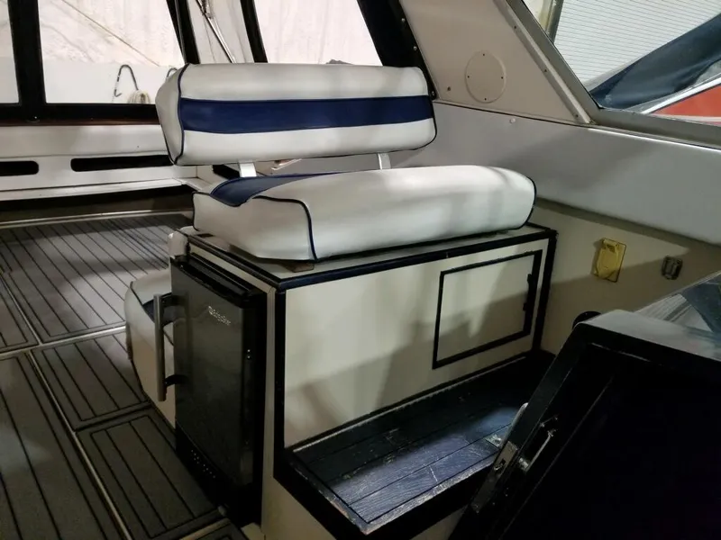 Slide: The Image of 1986 Sea Ray 390 Express interior with cushioned seating and storage. - 3
