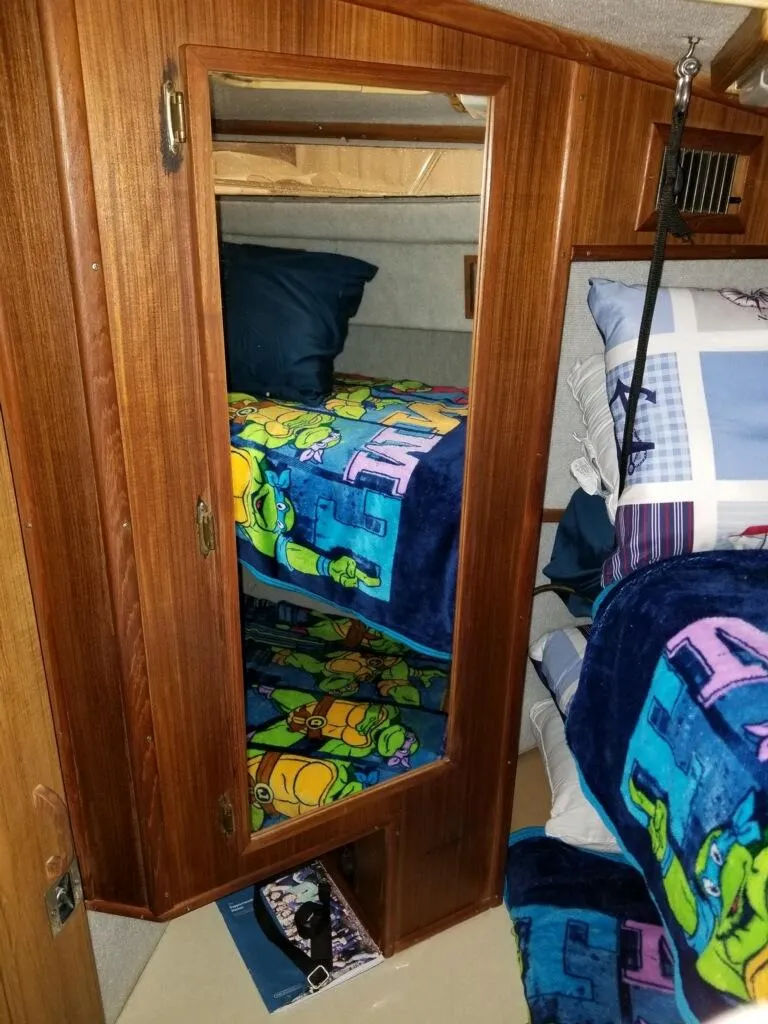 Slide: The Image of Interior of 1986 Sea Ray 390 Express with wooden cabinet and colorful bedding. - 5