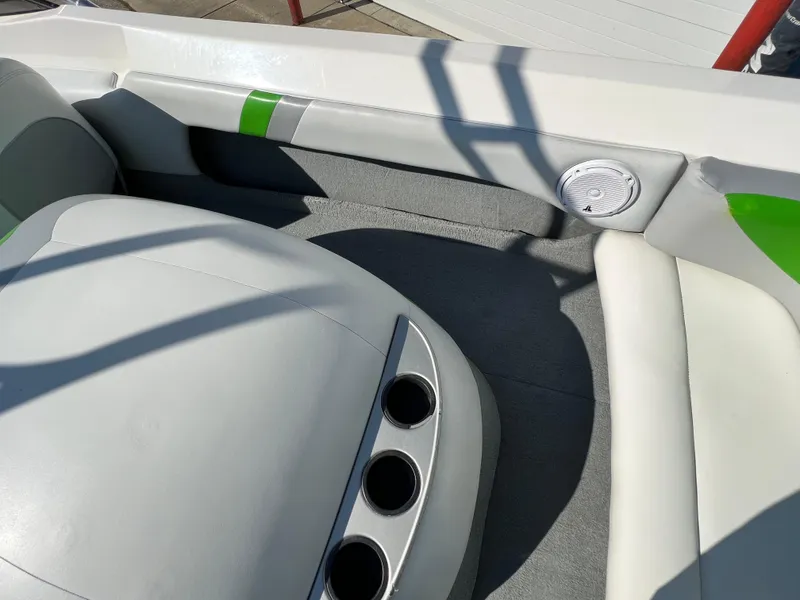 Slide: The Image of 2003 MasterCraft X5 boat interior with gray and white seating, green accents, and cup holders. - 11