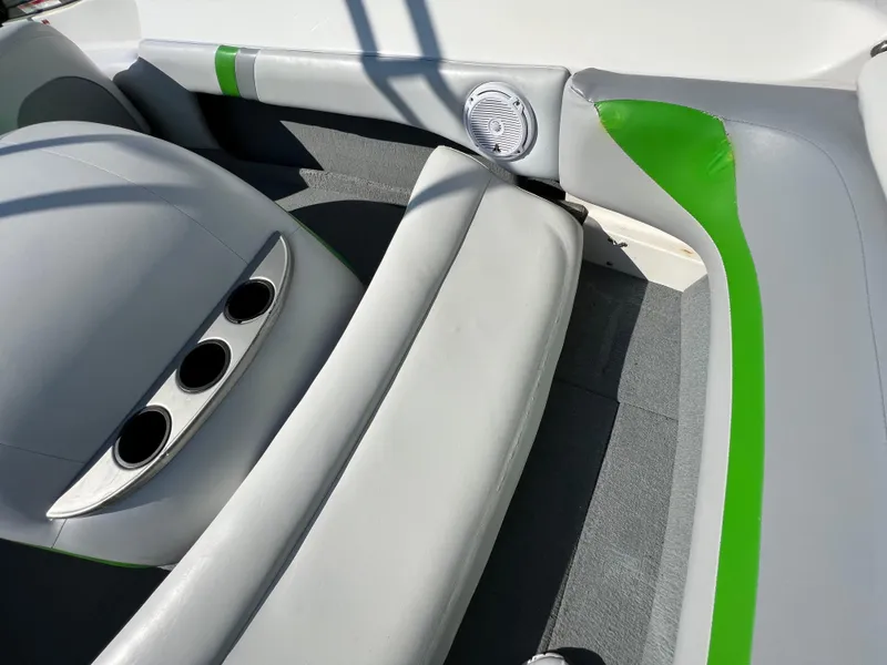 Slide: The Image of 2003 MasterCraft X5 boat interior with gray and green seating and cup holders. - 18