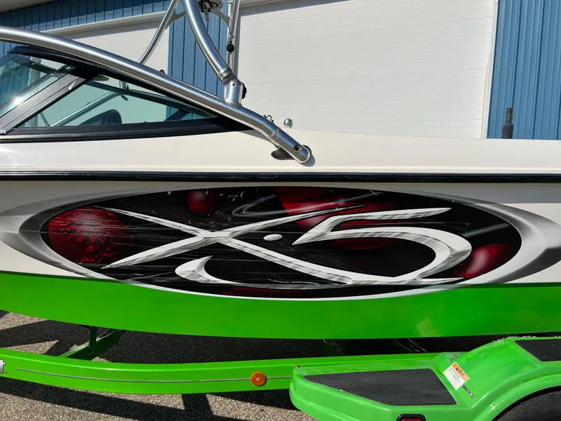 Slide: The Image of 2003 MasterCraft X5 boat with vibrant green detailing and sleek design. - 20