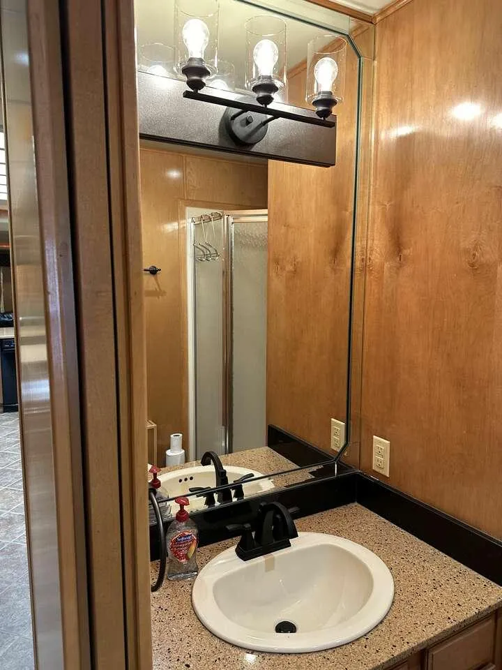 Slide: The Image of Bathroom vanity with mirror, modern lighting, and sink in 2005 Sumerset Top Hat model. - 15