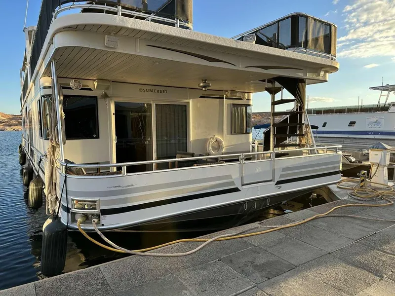 Slide: The Image of 2005 Sumerset Top Hat houseboat docked, featuring multiple decks and modern design. - 2