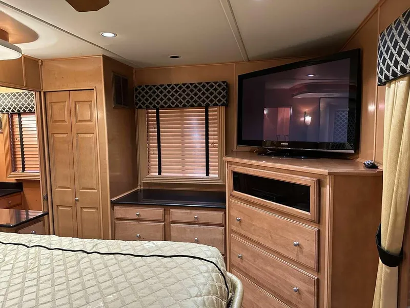 Slide: The Image of Interior of 2005 Sumerset Top Hat, featuring wood cabinetry, TV, and bed. - 20