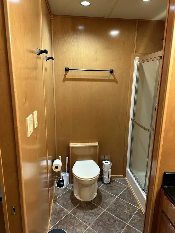 Slide: The Image of 2005 Sumerset Top Hat bathroom with wooden walls, toilet, and shower. - 22