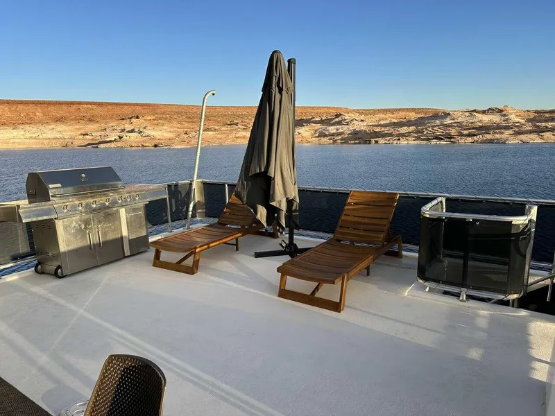 Slide: The Image of 2005 Sumerset Top Hat houseboat deck with loungers, grill, and umbrella by the water. - 23