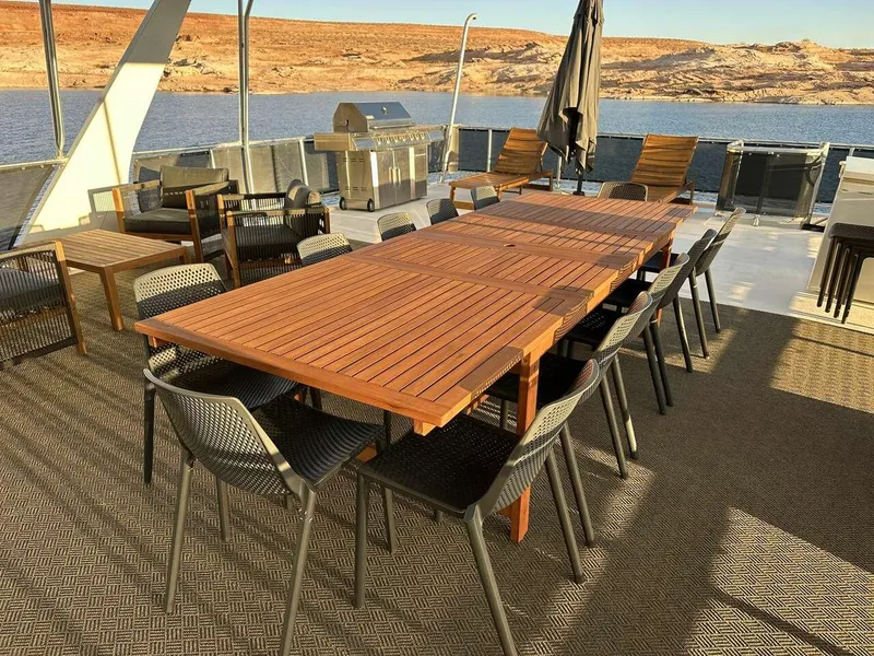 Slide: The Image of Outdoor dining area on 2005 Sumerset Top Hat houseboat, featuring wooden tables and chairs by the water. - 26