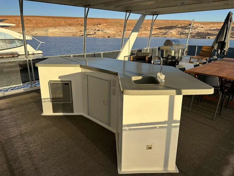 Slide: The Image of Outdoor kitchen on 2005 Sumerset Top Hat houseboat, featuring sink and counter, docked by a lake. - 28