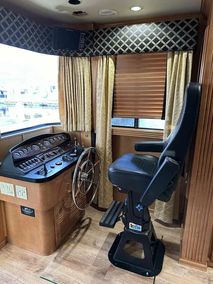 Slide: The Image of Captain's helm in 2005 Sumerset Top Hat houseboat with luxurious seating and control panel. - 3