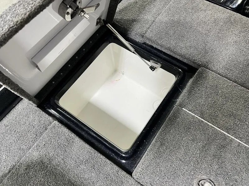 Slide: The Image of Open storage compartment in 2022 Phoenix 919 Pro XP boat, featuring gray carpeted interior. - 17