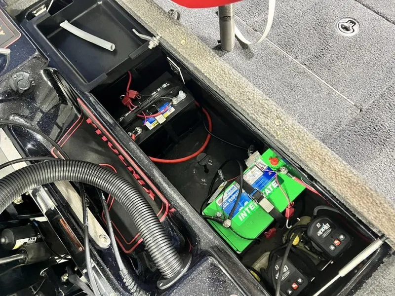 Slide: The Image of 2022 Phoenix 919 Pro XP boat battery compartment with wiring and storage. - 23