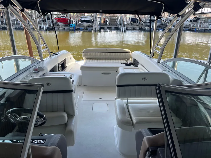 Slide: The Image of 2013 Cobalt A28 boat interior with white leather seating at a marina. - 13
