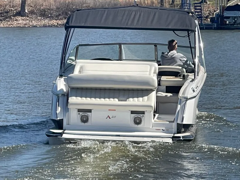 Slide: The Image of 2013 Cobalt A28 boat cruising on a lake with a person at the helm. - 4