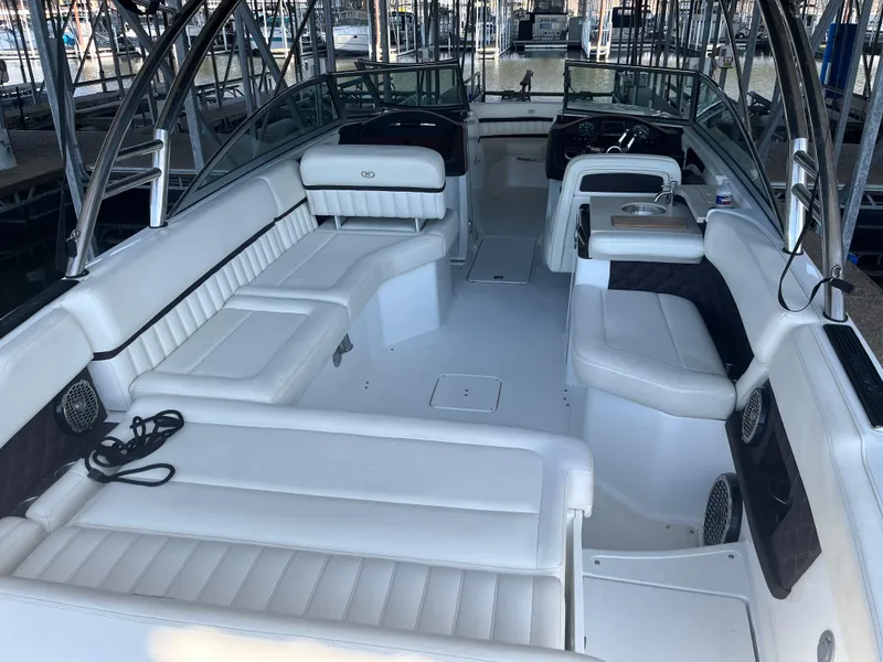 Slide: The Image of 2013 Cobalt A28 boat interior with white leather seating in a marina. - 7