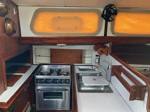 Slide: The Image of 1969 Spencer 44 CC yacht kitchen with stove, sink, and wooden cabinetry. - 18
