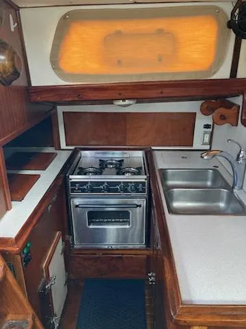 Slide: The Image of 1969 Spencer 44 CC yacht kitchen with stove, sink, and wooden cabinetry. - 19