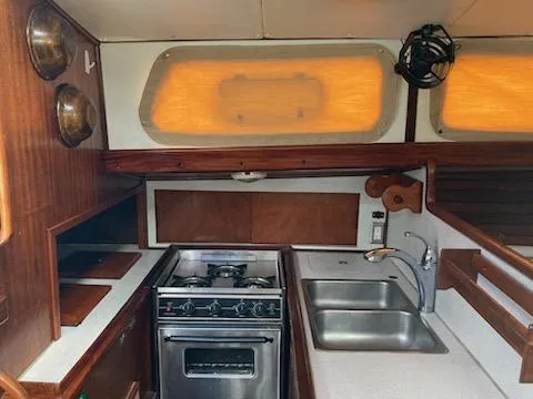 Slide: The Image of 1969 Spencer 44 CC yacht kitchen with stove, sink, and wooden cabinetry. - 22