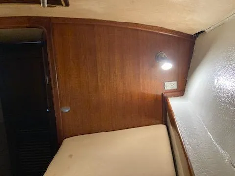 Slide: The Image of Interior cabin of a 1969 Spencer 44 CC sailboat with wooden paneling and a bed. - 39