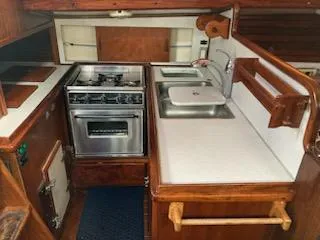 Slide: The Image of 1969 Spencer 44 CC yacht kitchen with stove, sink, and wooden cabinetry. - 43