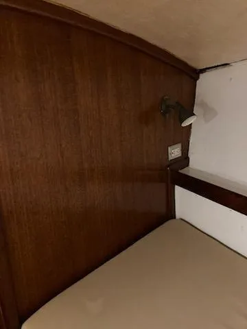 Slide: The Image of 1969 Spencer 44 CC boat interior cabin with wooden paneling and bed. - 45