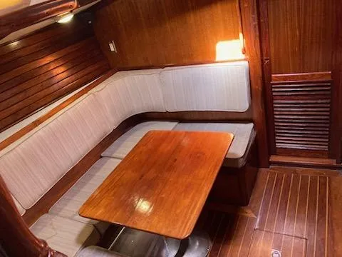 Slide: The Image of 1969 Spencer 44 CC sailboat interior with wooden table and cushioned seating. - 6