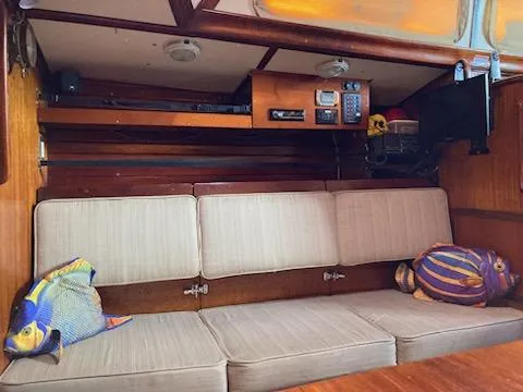 Slide: The Image of Interior of a 1969 Spencer 44 CC sailboat with beige cushions and fish-themed pillows. - 7