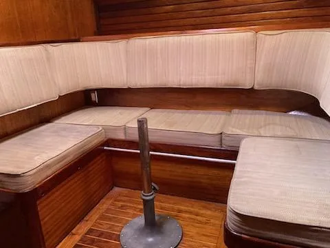 Slide: The Image of 1969 Spencer 44 CC sailboat interior with cushioned seating and wooden paneling. - 9