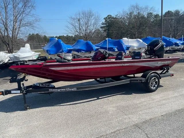 The Image of 2024 Ranger RT188 boat in red on a trailer, parked outdoors. - 0