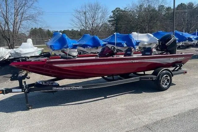 Slide: The Image of 2024 Ranger RT188 boat in red on a trailer, parked outdoors. - 8