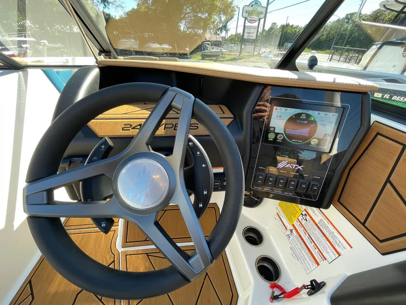 Slide: The Image of 2024 ATX Surf Boats 24 Type-S dashboard with steering wheel and touchscreen display. - 3