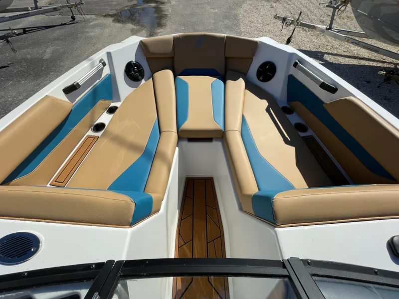Slide: The Image of 2024 ATX Surf Boats 24 Type-S bow seating area with tan and blue upholstery. - 5