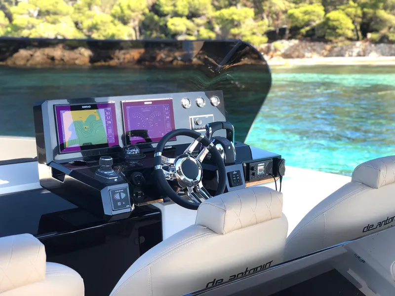Slide: The Image of 2024 De Antonio Yachts D42 Open helm with modern controls, overlooking clear turquoise waters. - 15