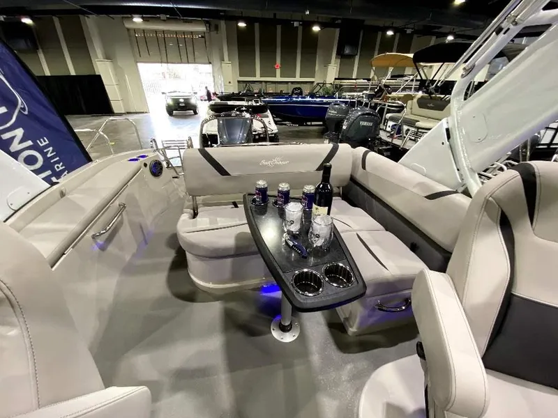 Slide: The Image of 2024 SunChaser Calais 23 SB DC boat interior with seating and table at a boat show. - 11