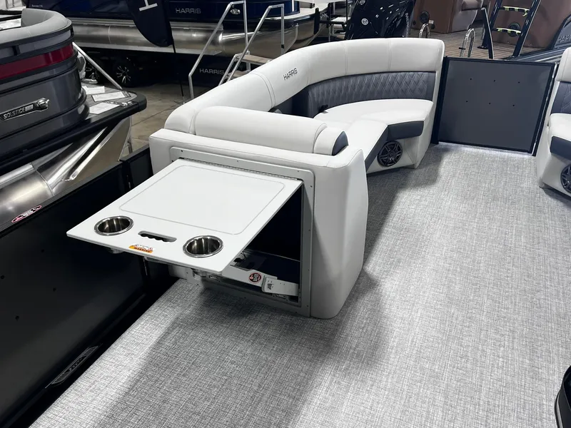 Slide: The Image of 2024 Harris Sunliner 230 boat interior with fold-out table and cup holders. - 12