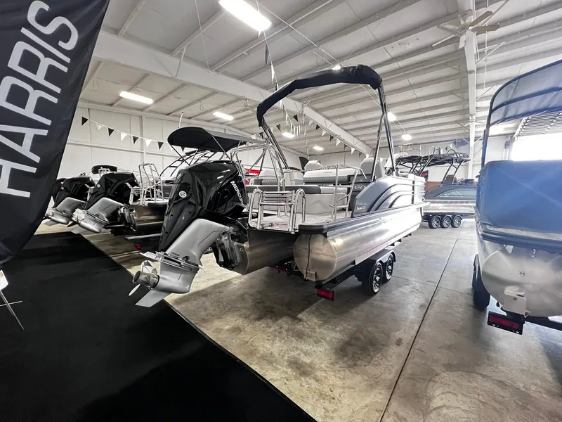 Slide: The Image of 2024 Harris Sunliner 230 pontoon boat displayed in an indoor showroom. - 26