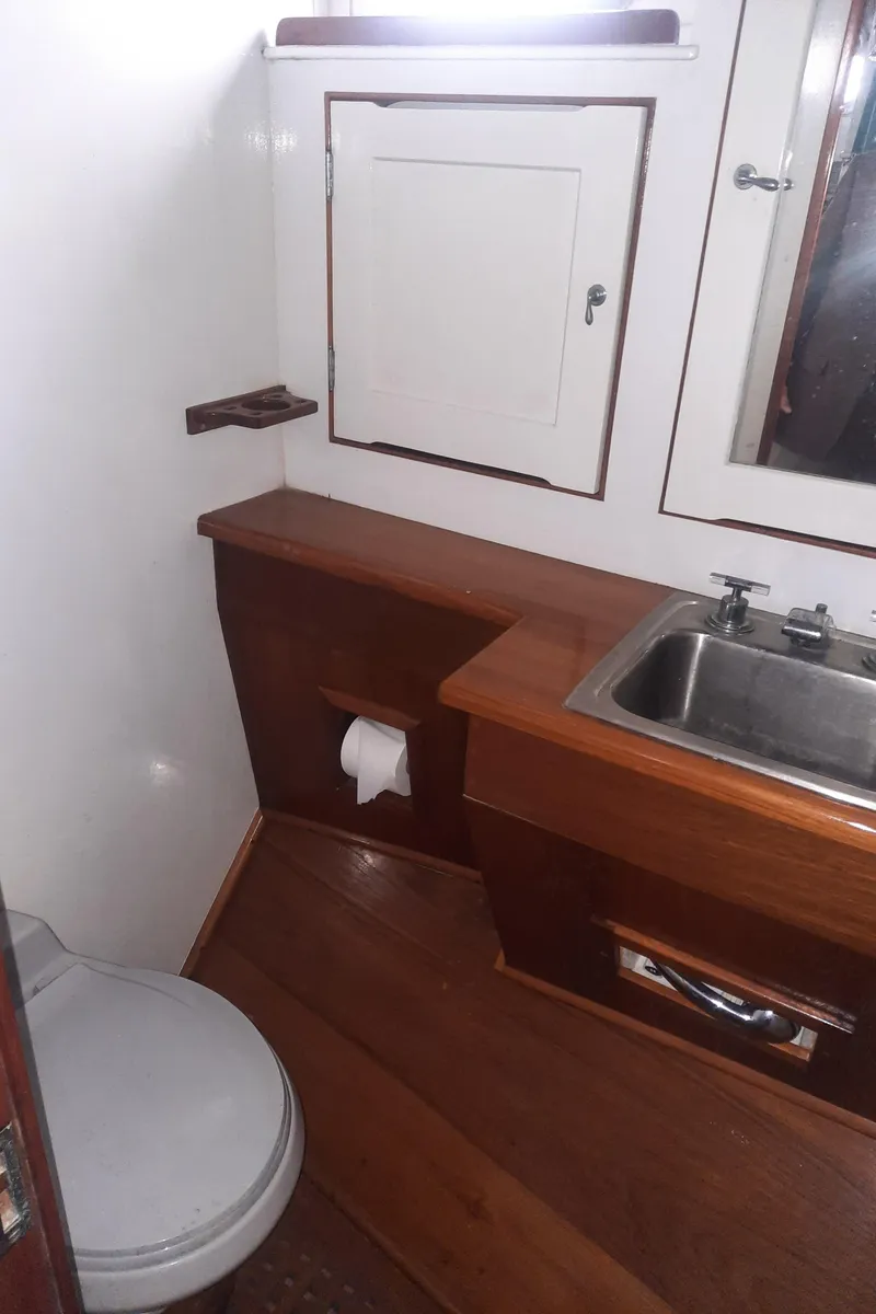 Slide: The Image of 1947 Rhodes Nevins Picnic Boat bathroom with wooden cabinetry and stainless steel sink. - 12