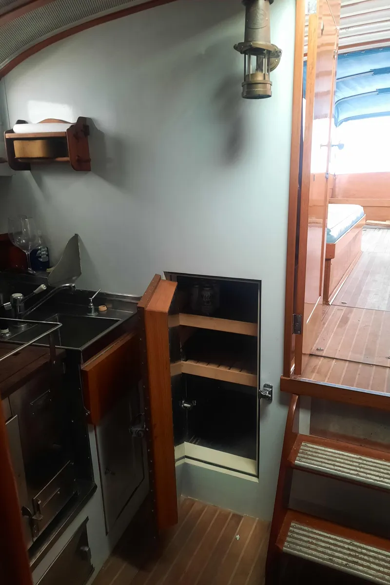 Slide: The Image of Interior of a 1947 Rhodes Nevins Picnic Boat with wooden cabinetry and compact kitchen area. - 14