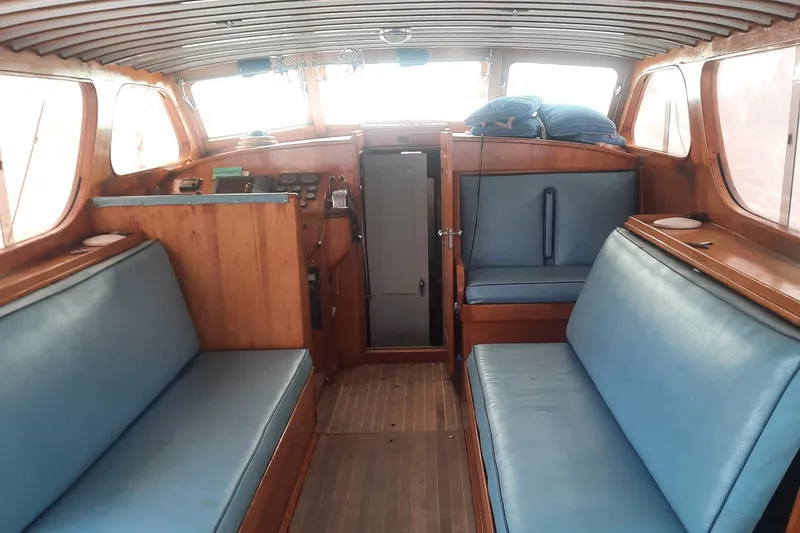 Slide: The Image of Interior of a 1947 Rhodes Nevins Picnic Boat with blue seating and wooden finishes. - 3