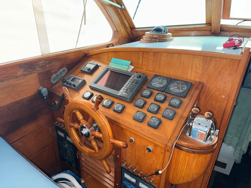 Slide: The Image of 1947 Rhodes Nevins Picnic Boat helm with wooden wheel and navigation instruments. - 5