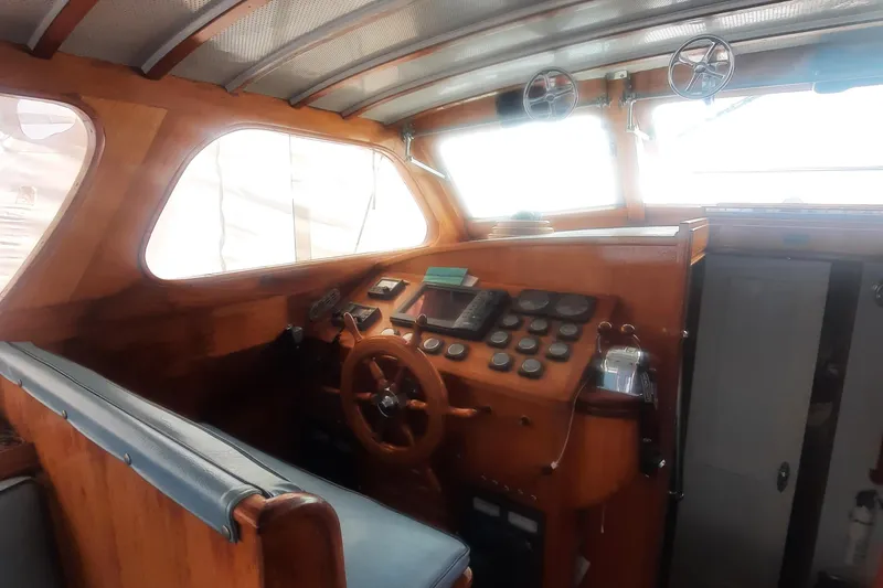 Slide: The Image of Interior of a 1947 Rhodes Nevins Picnic Boat with wooden dashboard and steering wheel. - 6