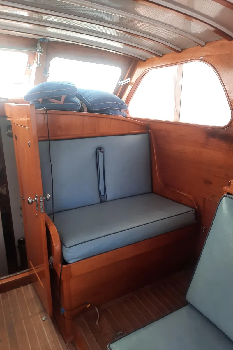 Slide: The Image of 1947 Rhodes Nevins Picnic Boat interior with wooden seating and blue cushions. - 7