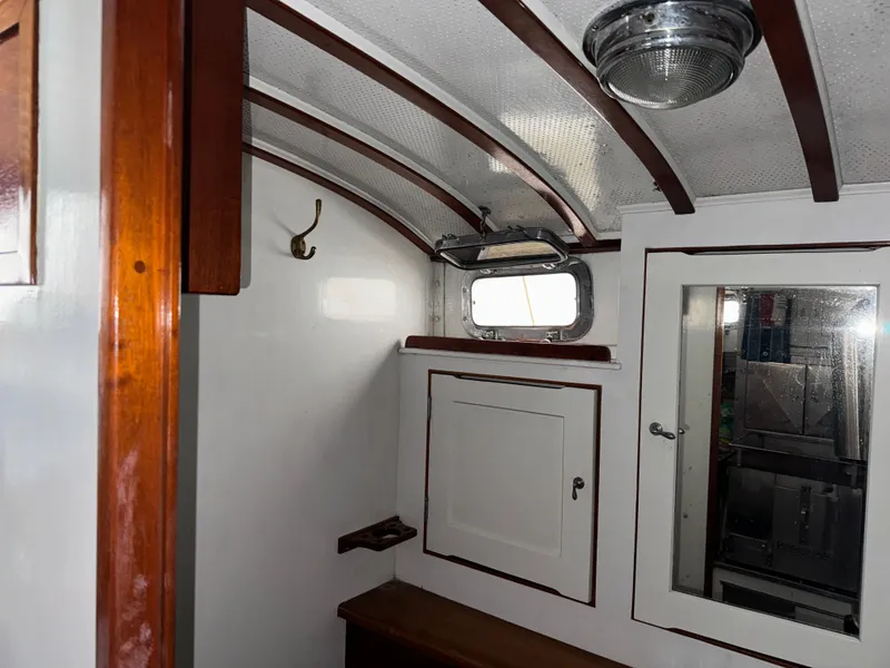 Slide: The Image of Interior of 1947 Rhodes Nevins Picnic Boat with wooden accents and porthole window. - 9
