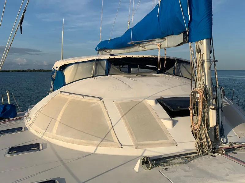 Slide: The Image of 1993 Lagoon TPI 42 sailboat with blue sail cover on calm water. - 14