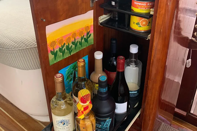 Slide: The Image of Liquor cabinet on 1993 Lagoon TPI 42 yacht with assorted bottles and artwork. - 28