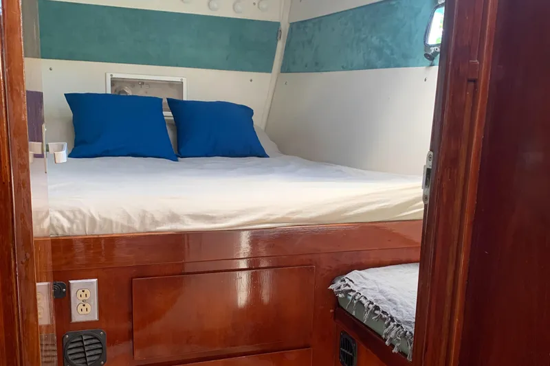 Slide: The Image of Cozy cabin interior of 1993 Lagoon TPI 42 with bed and blue pillows. - 44