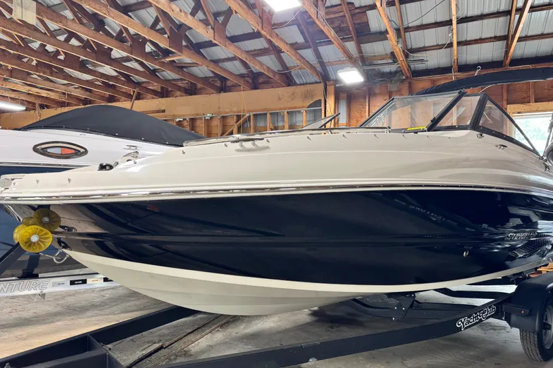 The Image of 2024 Stingray 201 DC boat in a wooden garage, showcasing sleek design and modern features. - 0