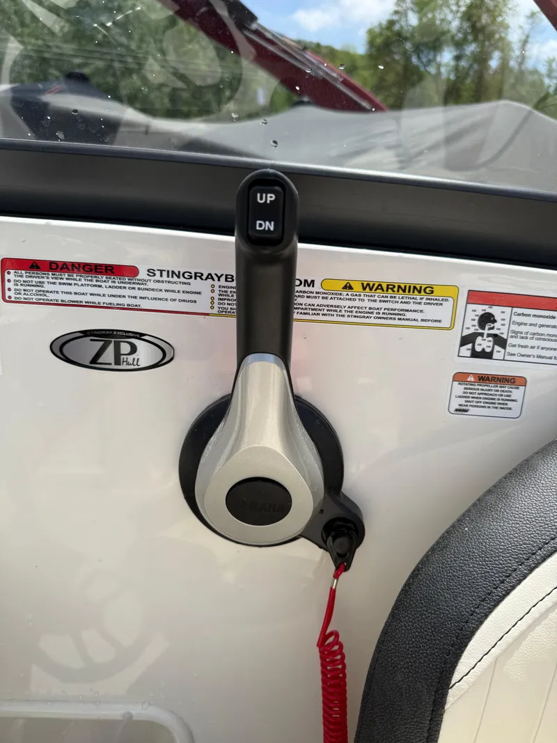 Slide: The Image of Throttle control of 2024 Stingray 201DC boat with safety warnings and red cord. - 15