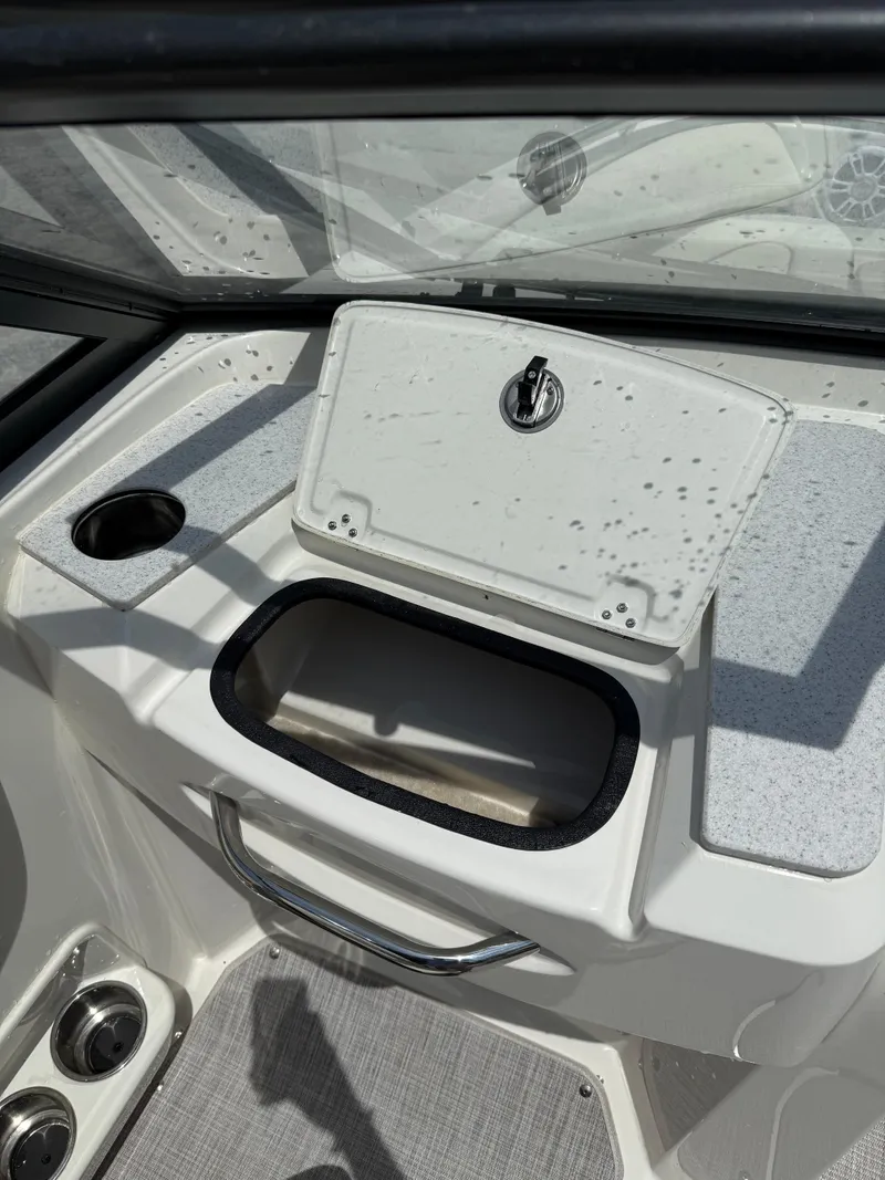 Slide: The Image of 2024 Stingray 201DC boat interior with storage compartment and cup holder. - 18
