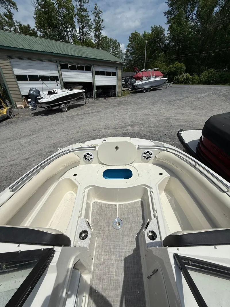 Slide: The Image of 2024 Stingray 201DC boat interior at a marina with other boats. - 22