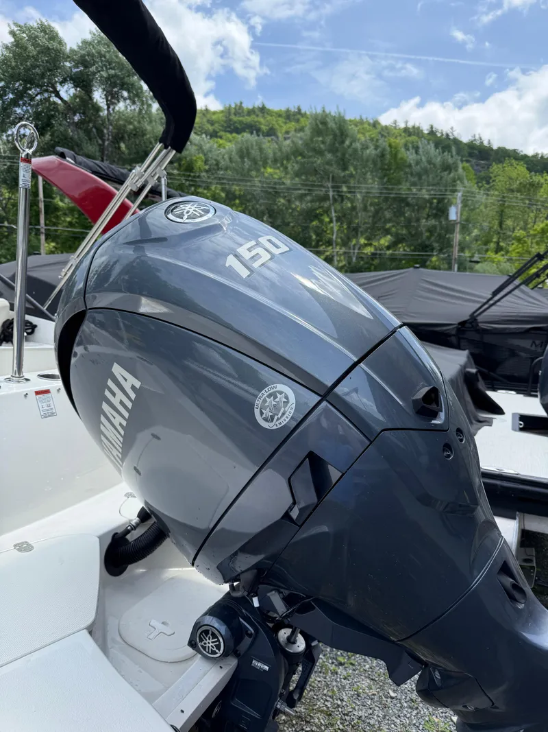 Slide: The Image of 2024 Stingray 201DC boat with Yamaha 150 outboard motor, outdoors. - 6